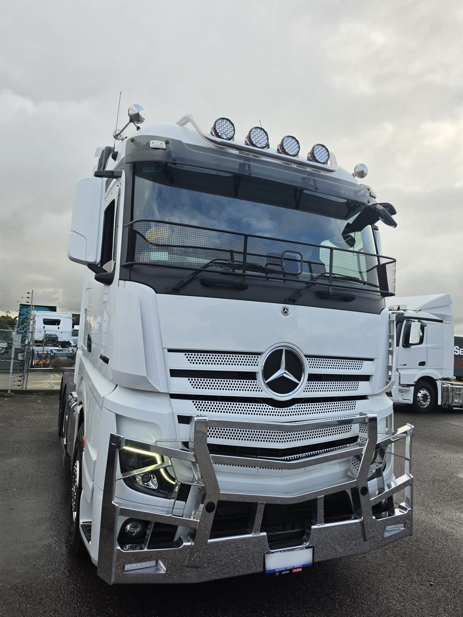 White Mercedes-Benz Actros prime mover with a bull bar, parked in the yard
